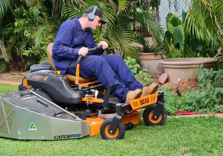 Person operating a riding lawn mower